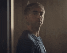 a man in a striped shirt has a tattoo on his neck