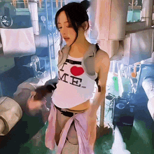 a woman is wearing a white tank top that says i love me
