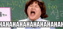 a woman is laughing with her mouth open in front of a blackboard with chinese writing on it .