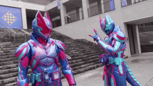a couple of superhero costumes are standing next to each other in front of a building .