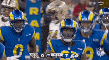 a group of football players are standing next to each other on the field during a game .