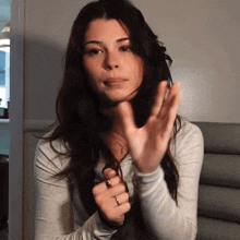 a woman wearing a ring on her finger is giving a thumbs up