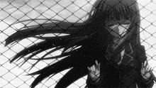 a black and white photo of a girl behind a fence