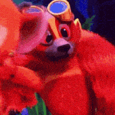 a close up of a red bear wearing goggles and a hat