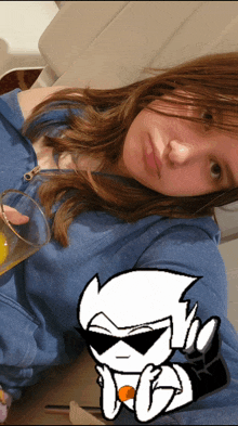 a girl in a blue sweatshirt holds a glass of orange juice next to a drawing of a white character with sunglasses
