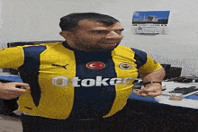 a man wearing a yellow and blue shirt that says otoko