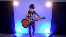 a man playing a guitar with a shirt that says " create music "