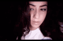 a close up of a girl 's face with a dark background