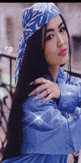 a woman wearing a blue jacket and a blue head scarf