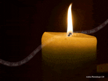 a yellow candle is lit up in the dark with adobe photoshop cs6