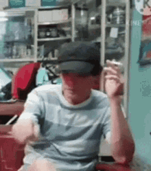 a man wearing a hat is sitting at a table smoking a cigarette