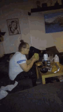 a woman is sitting on a couch holding a ball in her hand