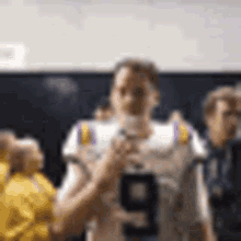 a football player wearing a number 9 jersey is holding a microphone in a locker room .