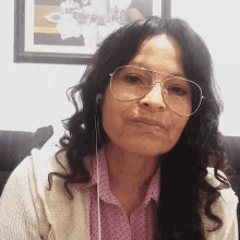 a woman wearing a pair of glasses and headphones looks at the camera
