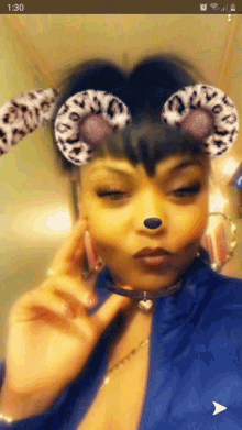 a woman wearing leopard print ears and hoop earrings takes a selfie