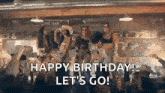 a group of women are dancing in a room with the words `` happy birthday ! let 's go '' .