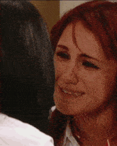a woman with red hair is crying while another woman kisses her cheek