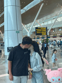 a man kisses a woman in front of a green exit sign