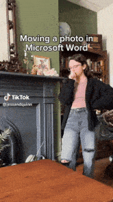 a woman standing in front of a fireplace with the caption moving a photo in microsoft word on it