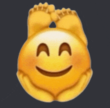 a smiley face with a pair of feet on it 's head