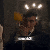 a man in a tuxedo is smoking a cigarette with a sticker that says smok3 above him