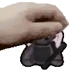 a hand is holding a black object in its palm .