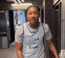 a woman in a minnesota lynx jersey stands in a hallway