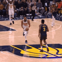 a basketball player with the number 3 on his jersey runs towards another player