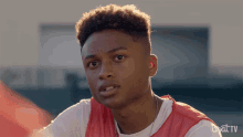 a young man wearing a red and white jersey with byatv on the bottom right