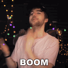 a man in a pink and white striped shirt with the word boom on it