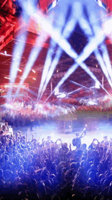 a crowd of people are watching a concert with a lot of lights on