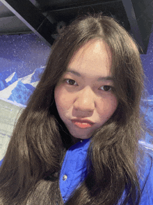 a woman in a blue jacket is making a funny face