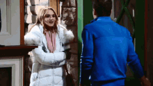 a woman in a white coat is standing next to a man in a blue shirt