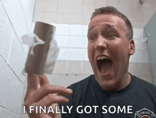 a man in a fire dept shirt is holding a roll of toilet paper and saying " i finally got some "