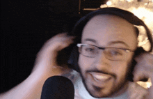 a bald man wearing glasses and headphones is smiling