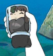 a person is holding a cartoon character in their hand