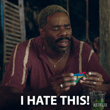 a man with a beard is holding a cube and says i hate this netflix