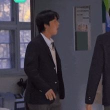 a man in a suit is standing in front of a sign that says ' ( ) '