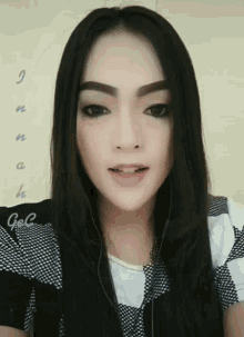 a woman wearing headphones and a black and white shirt with the word gel on it