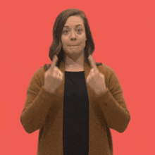 a woman in a brown cardigan is pointing up