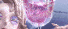 a woman with purple eyes is standing next to a glass of pink liquid