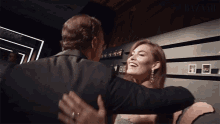 a man and a woman are hugging in front of a sign that says bazaar