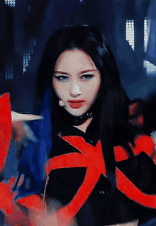 a woman with blue hair and a red ribbon around her neck