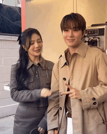 a man and a woman are standing next to each other and the man is pointing