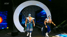 two wrestlers are walking in front of a circle with aew written on the bottom