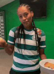 a woman wearing a green and white striped shirt with palmeiras on it