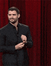 a man in a suit is giving a thumbs up .