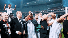a man in a besiktas shirt holds a trophy in his hand