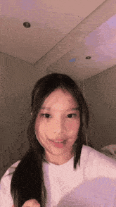 a girl with long hair is standing in front of a mirror
