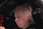 a young man is sitting in the driver 's seat of a car .